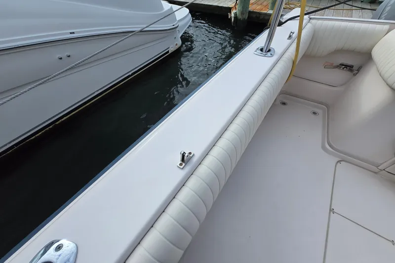 Slide: The Image of 2005 Grady-White Marlin 300 boat interior with cushioned seating and dock view. - 12