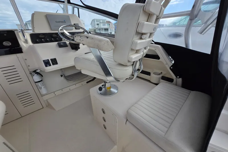 Slide: The Image of 2005 Grady-White Marlin 300 helm with Garmin navigation, featuring comfortable seating and controls. - 15