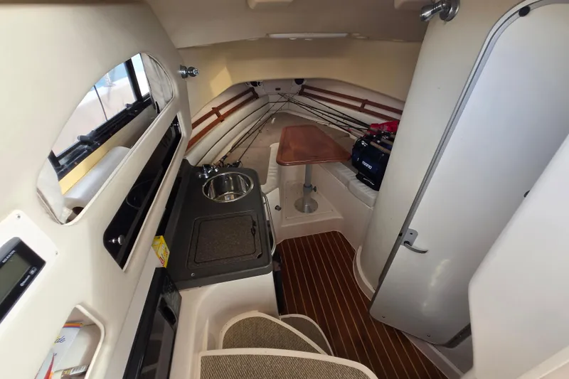 Slide: The Image of 2005 Grady-White Marlin 300 cabin interior with kitchenette and seating area. - 23