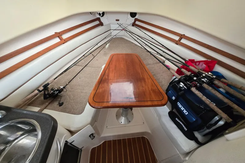 Slide: The Image of 2005 Grady-White Marlin 300 cabin interior with fishing rods and wooden table. - 27