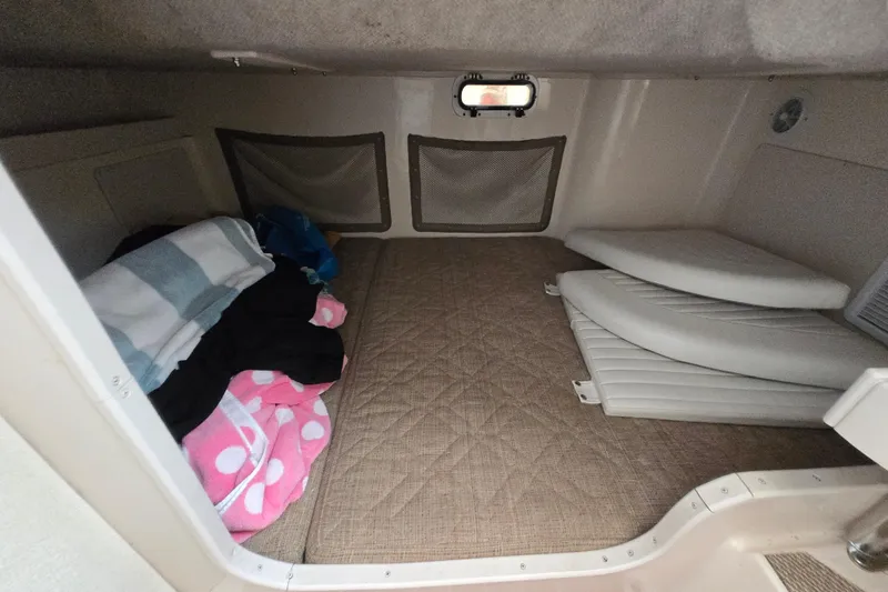 Slide: The Image of 2005 Grady-White Marlin 300 cabin interior with bedding and cushions. - 34