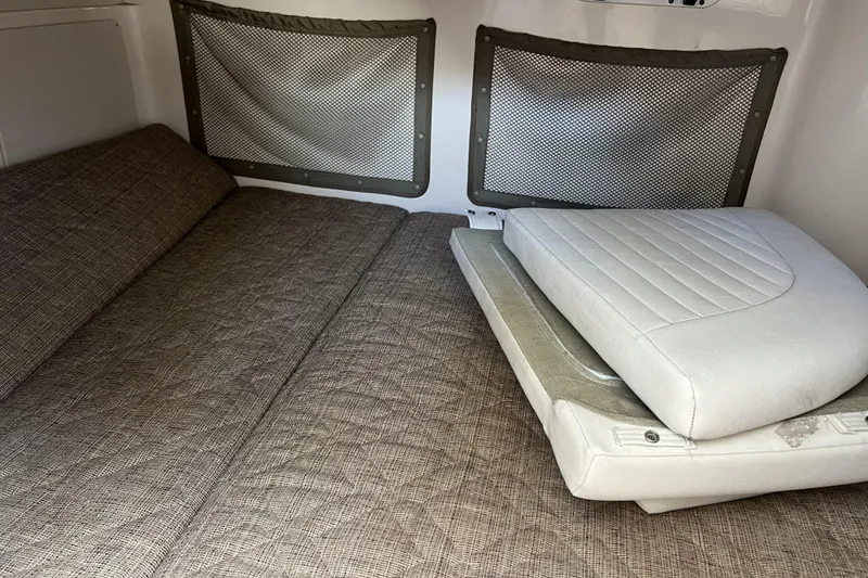 Slide: The Image of 2005 Grady-White Marlin 300 cabin interior with cushioned seating and storage nets. - 40