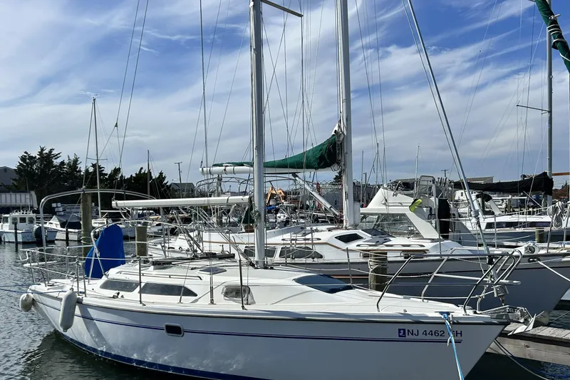 Slide: The Image of 1999 Catalina 28 MkII sailboat on calm water under clear blue sky. - 14