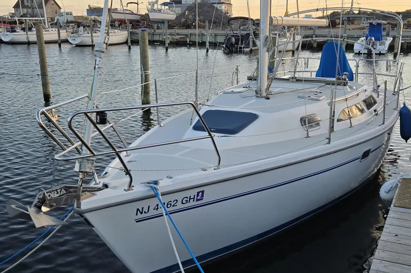 Slide: The Image of 1999 Catalina 28 MkII sailboat docked at marina with nearby vehicles. - 4