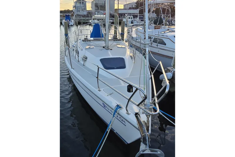 Slide: The Image of 1999 Catalina 28 MkII sailboat interior with wooden table, blue seating, and cozy cabin layout. - 9