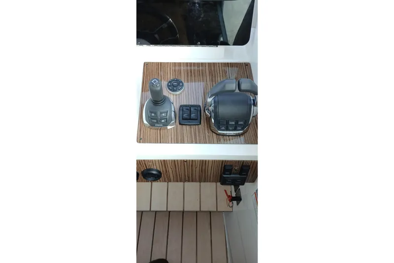 Slide: The Image of 2014 Cruisers Yachts 41 Cantius helm controls with joystick and throttle on wood panel. - 13