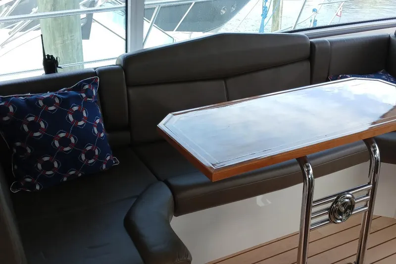 Slide: The Image of Interior of 2014 Cruisers Yachts 41 Cantius with cushioned seating and nautical-themed pillows. - 17
