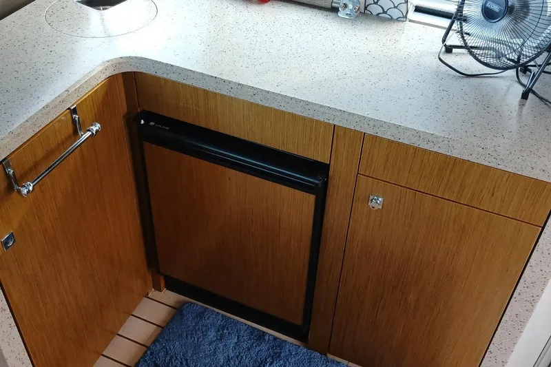 Slide: The Image of 2014 Cruisers Yachts 41 Cantius kitchen with wood cabinets and compact fridge. - 18