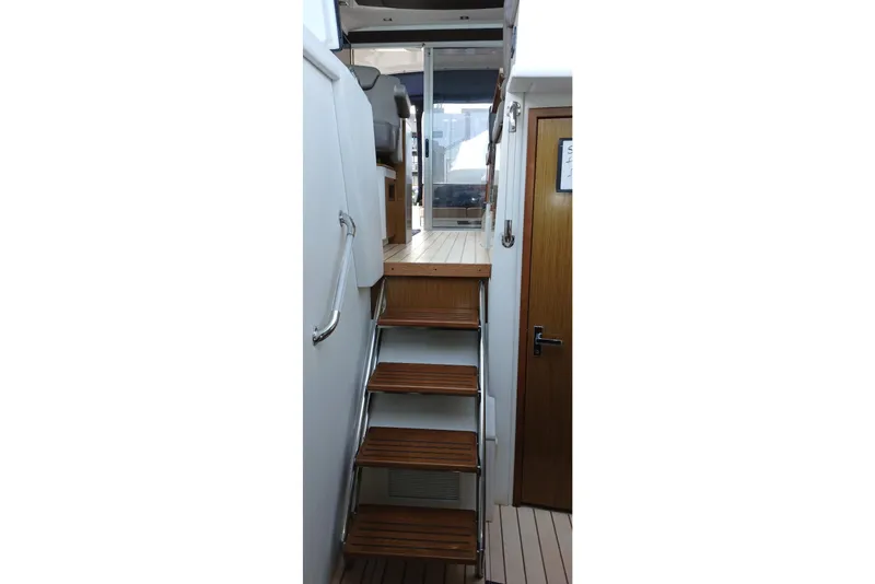 Slide: The Image of Staircase inside 2014 Cruisers Yachts 41 Cantius, featuring wooden steps and sleek design. - 19