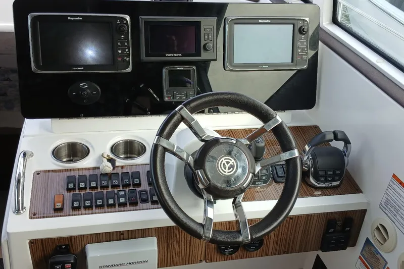 Slide: The Image of 2014 Cruisers Yachts 41 Cantius helm with navigation controls and steering wheel. - 8