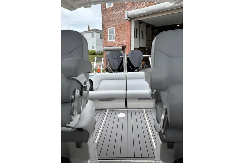 Slide: The Image of 2020 Protector 310 Targa boat interior with gray seating and dual outboard motors. - 11