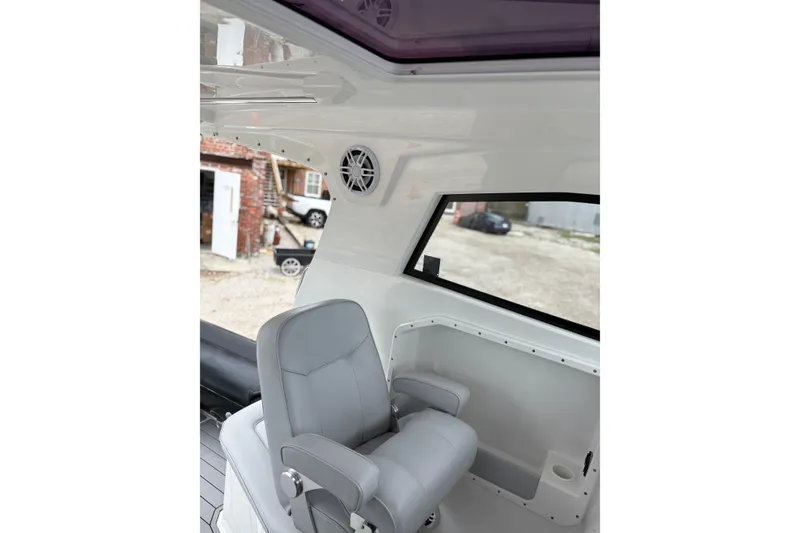 Slide: The Image of Interior of 2020 Protector 310 Targa boat with gray seating and window view. - 14