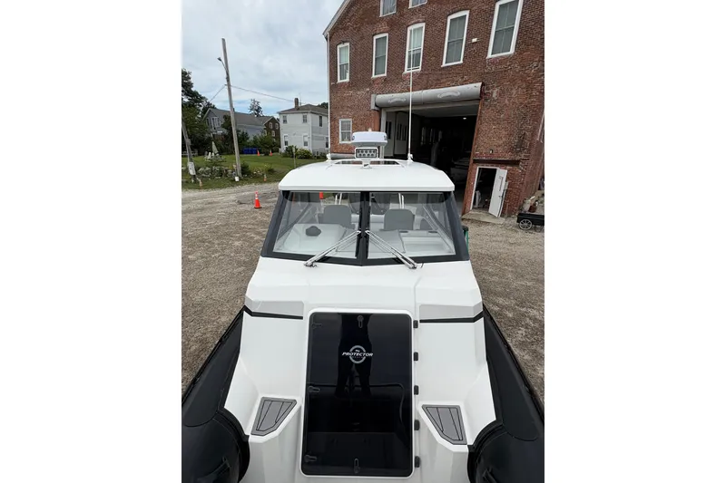 Slide: The Image of 2020 Protector 310 Targa boat parked outside a brick building. - 21