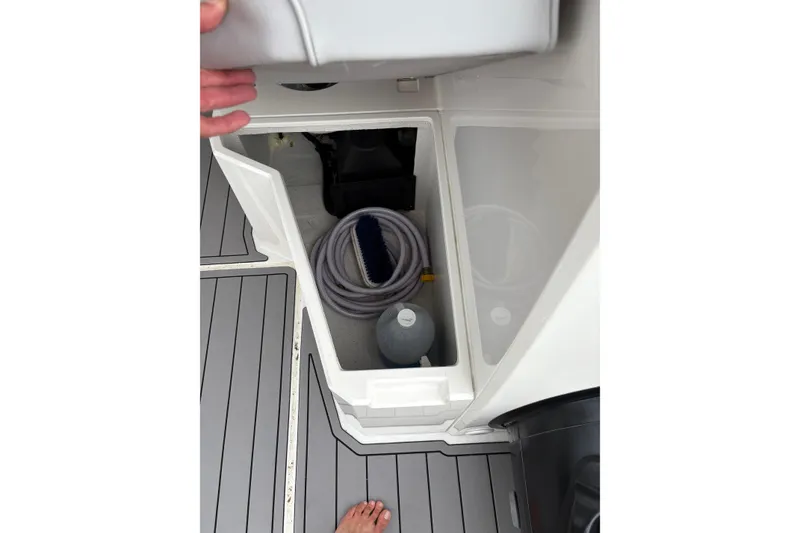 Slide: The Image of Storage compartment on 2020 Protector 310 Targa boat with hose and cleaning supplies. - 24