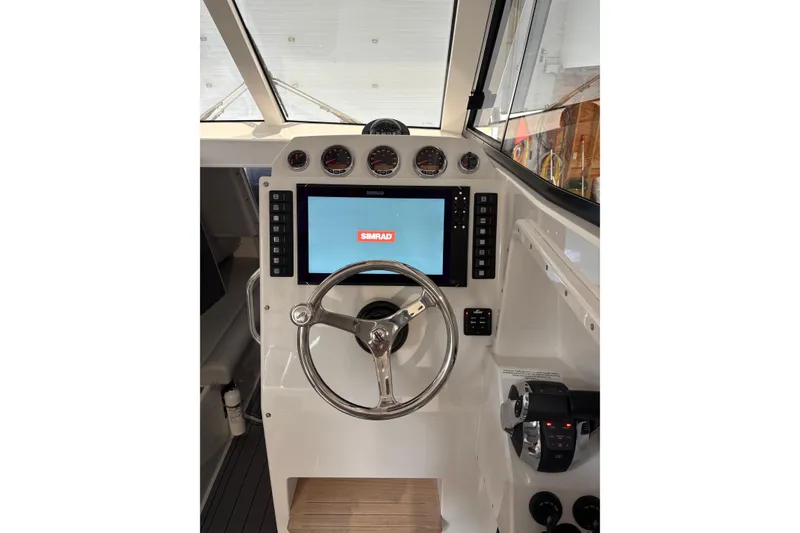 Slide: The Image of Cockpit of 2020 Protector 310 Targa with Simrad navigation system and steering wheel. - 26