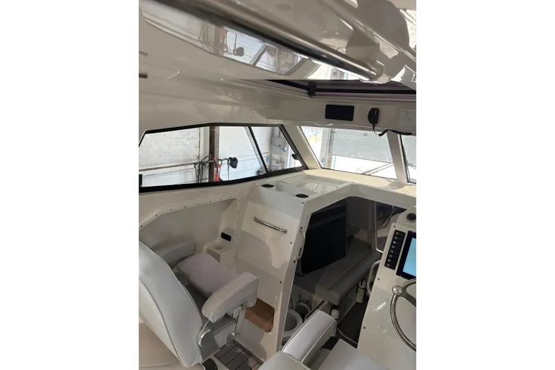 Slide: The Image of Interior of 2020 Protector 310 Targa boat, featuring modern helm and seating. - 29
