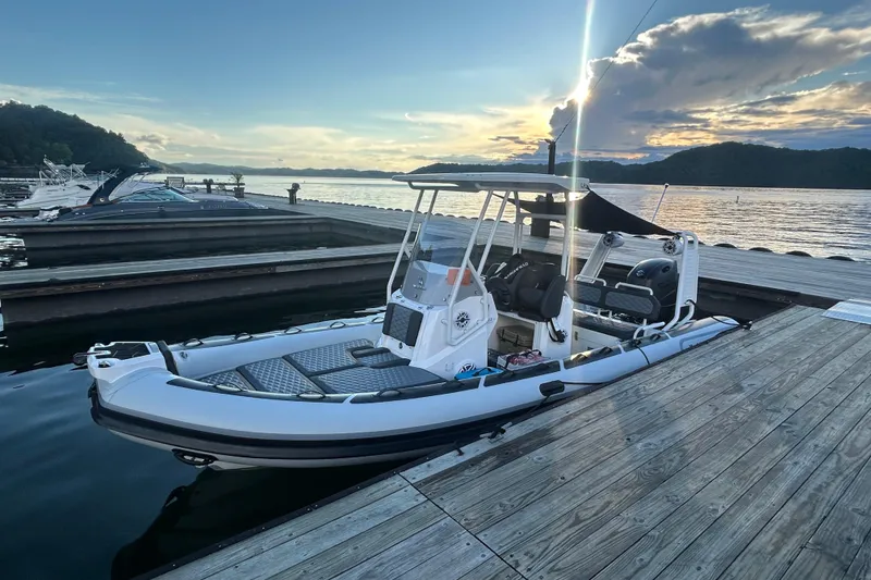 The Image of 2025 Highfield Sport 660 boat docked at sunset, with scenic water and sky backdrop. - 1