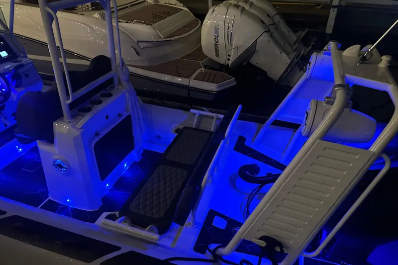 Slide: The Image of 2025 Highfield Sport 660 boat interior with blue LED lighting and Mercury engines. - 10