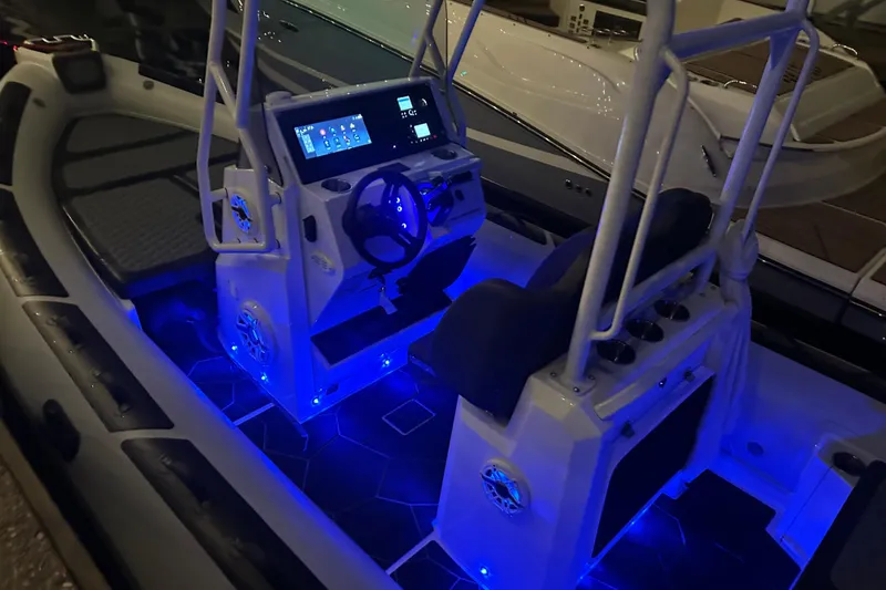Slide: The Image of 2025 Highfield Sport 660 boat interior with illuminated dashboard and seating. - 9