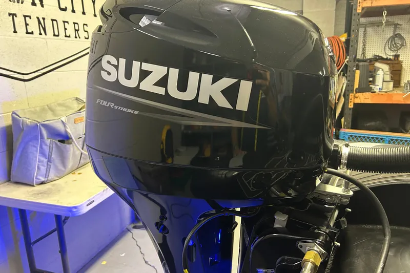 Slide: The Image of Suzuki four-stroke engine on 2025 Highfield Sport 360 boat in workshop setting. - 14