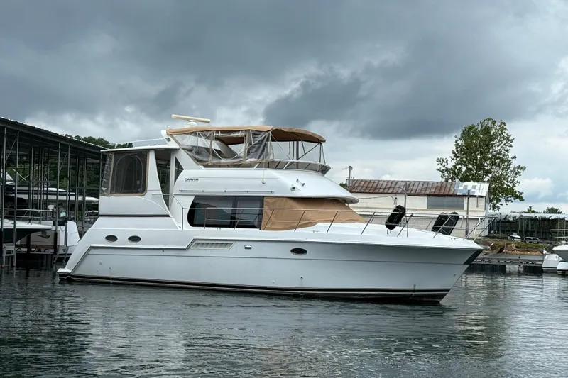 The Image of 2000 Carver 406 Aft Cabin Motor Yacht docked under cloudy skies. - 0