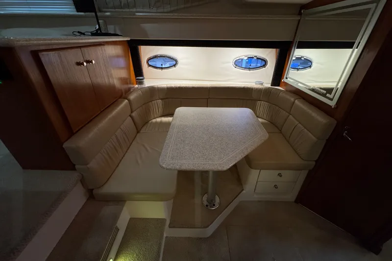 Slide: The Image of 2000 Carver 406 Aft Cabin Motor Yacht interior with beige seating and dining table. - 15