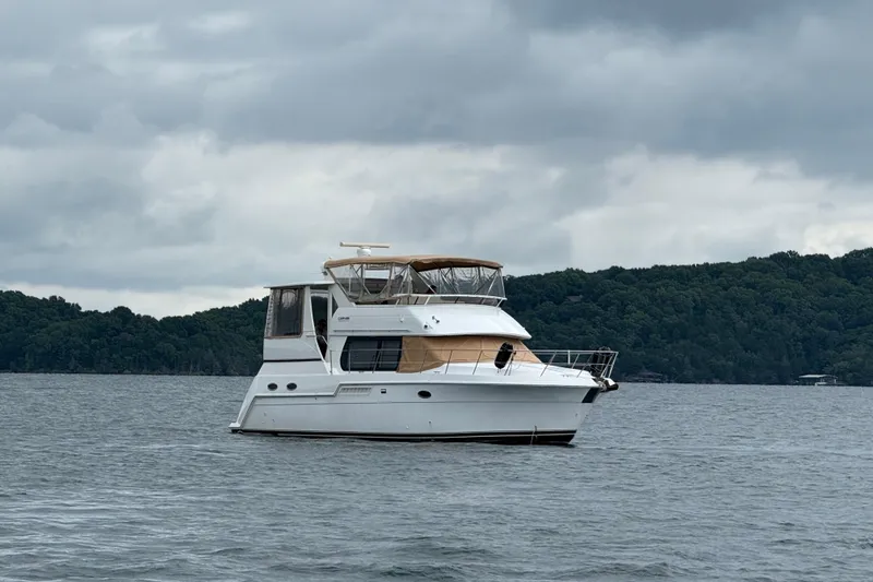 Slide: The Image of 2000 Carver 406 Aft Cabin Motor Yacht on a calm lake under cloudy skies. - 2