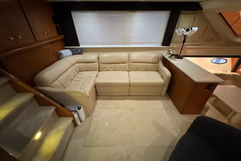 Slide: The Image of Interior of 2000 Carver 406 Aft Cabin Motor Yacht with beige leather seating and wooden cabinetry. - 13