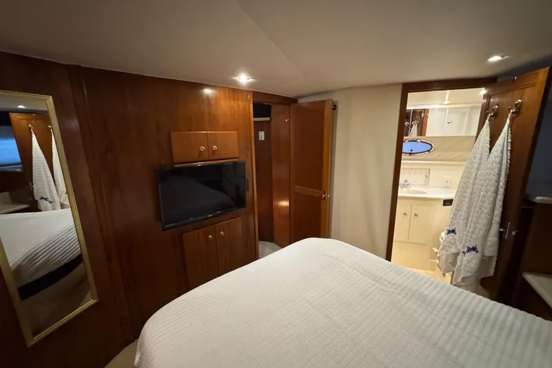Slide: The Image of Interior of 2000 Carver 406 Aft Cabin Motor Yacht with wood paneling and ensuite bathroom. - 24