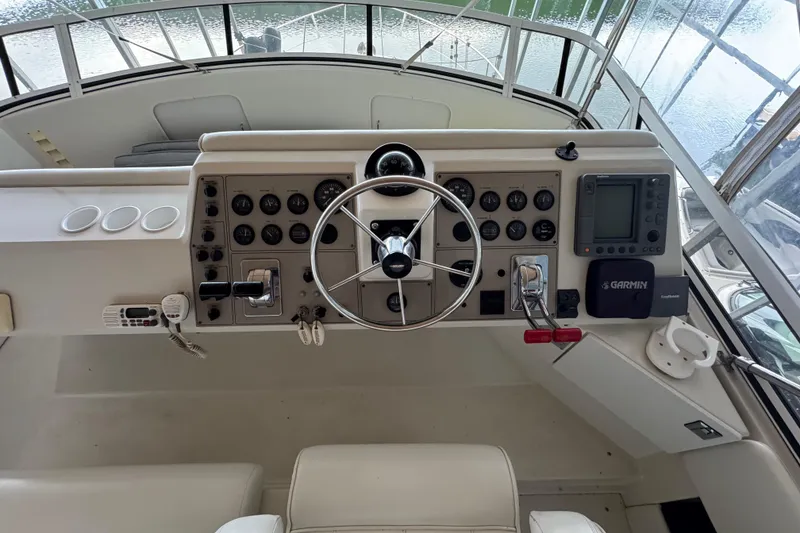 Slide: The Image of Control panel of a 2000 Carver 406 Aft Cabin Motor Yacht with steering wheel and navigation equipment. - 7