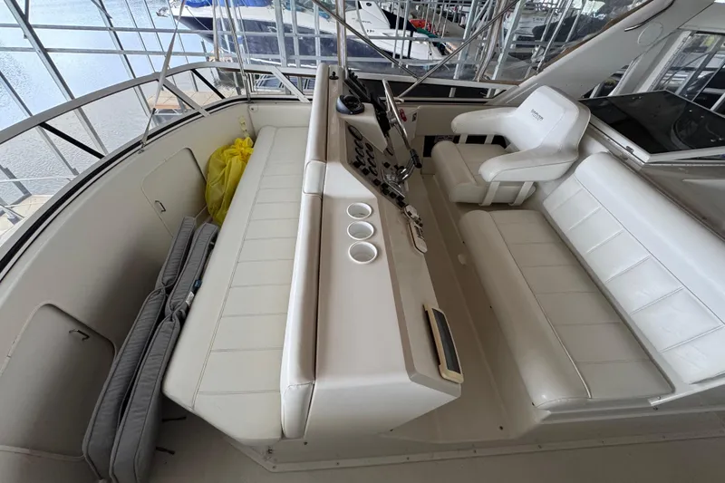 Slide: The Image of 2000 Carver 406 Aft Cabin Motor Yacht helm with white seating and control panel. - 8