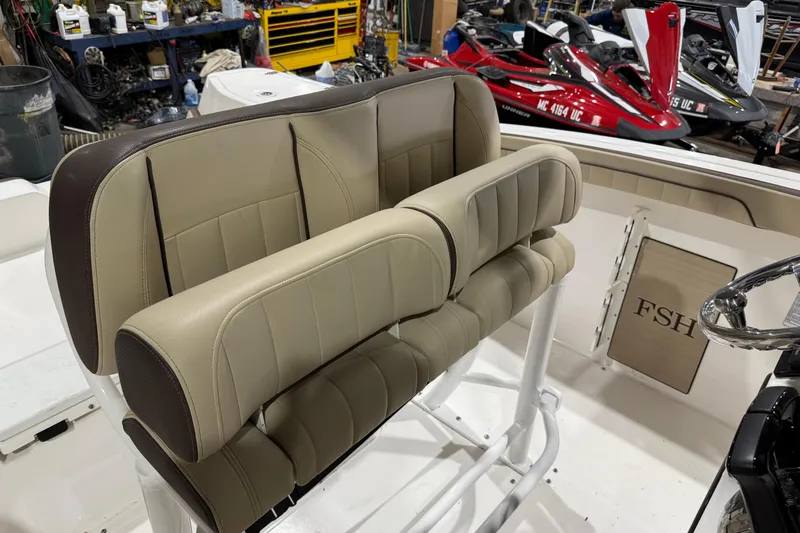 Slide: The Image of 2022 Yamaha Boats 255 FSH Sport E interior with beige seating and steering wheel. - 6