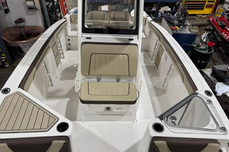 Slide: The Image of 2022 Yamaha Boats 255 FSH Sport E interior with beige seating and storage compartments. - 9