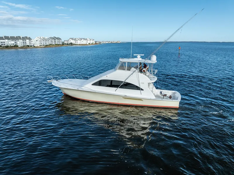 The Image of 2006 Ocean 57 yacht cruising on open water near coastal buildings. - 0