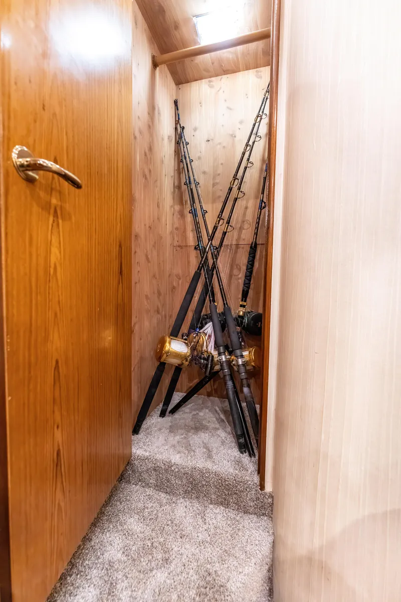 Slide: The Image of Fishing rods stored in a wooden closet on a 2006 Ocean 57 boat. - 32