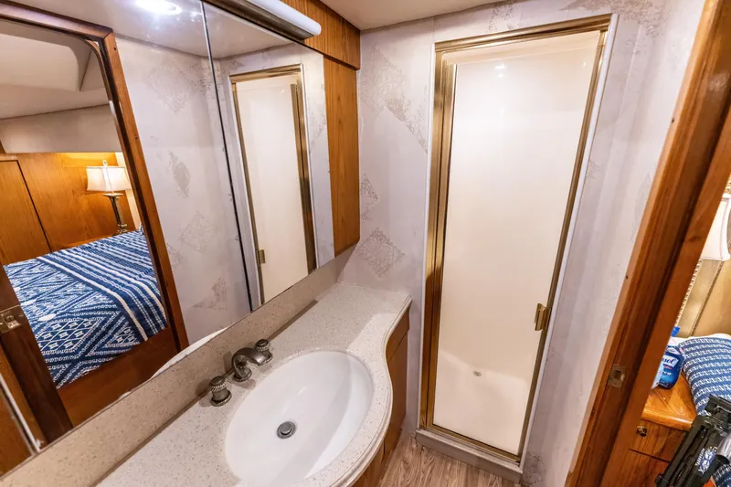 Slide: The Image of Luxurious 2006 Ocean 57 yacht bathroom with shower, sink, and mirrored cabinet. - 35