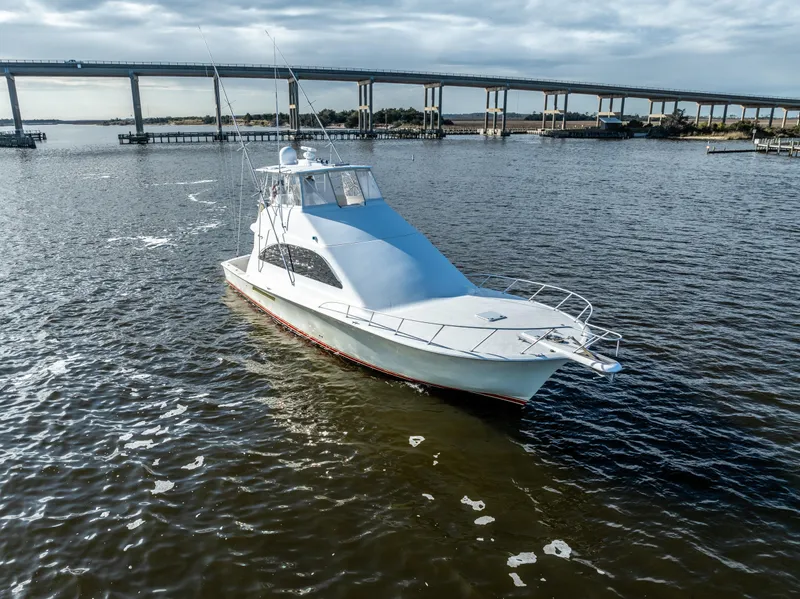 Slide: The Image of 2006 Ocean 57 yacht cruising on a serene river near a bridge. - 4