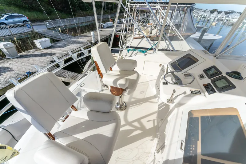 Slide: The Image of 2006 Ocean 57 yacht helm with white seating and navigation equipment at marina. - 44