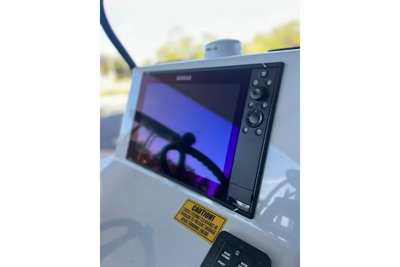 Slide: The Image of 2026 Chittum Skiffs 21 Islamorada boat console with navigation display and caution label. - 25
