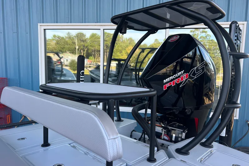 Slide: The Image of 2026 Chittum Skiffs 21 Islamorada with Mercury Pro XS engine, docked near blue building. - 30