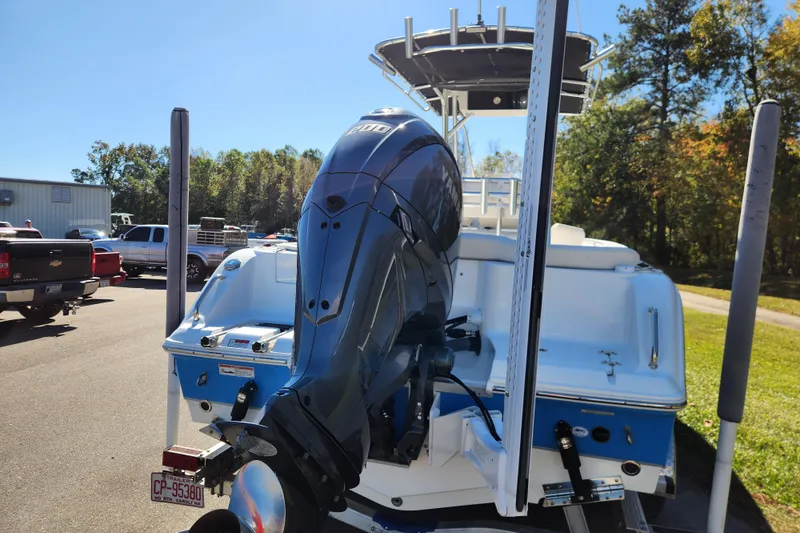 Slide: The Image of 2024 Sea Hunt Ultra 229 boat with powerful outboard motor in a parking lot. - 3