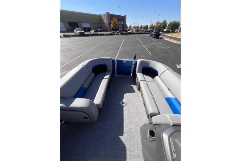 Slide: The Image of 2026 Sun Tracker Party Barge 22 RF DLX pontoon boat with spacious seating in a parking lot. - 11