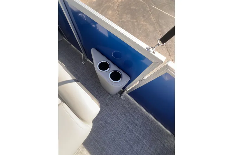 Slide: The Image of 2026 Sun Tracker Party Barge 22 RF DLX interior with dual cup holders and blue paneling. - 13