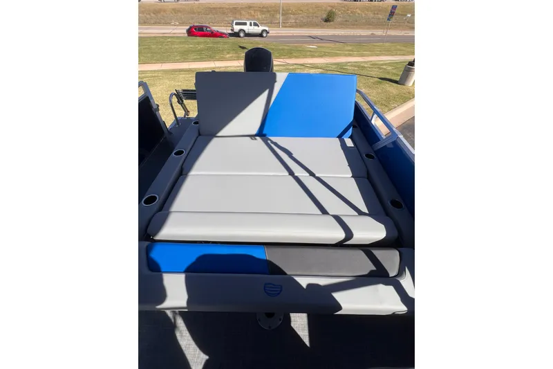 Slide: The Image of 2026 Sun Tracker Party Barge 22 RF DLX with gray and blue seating on deck. - 14