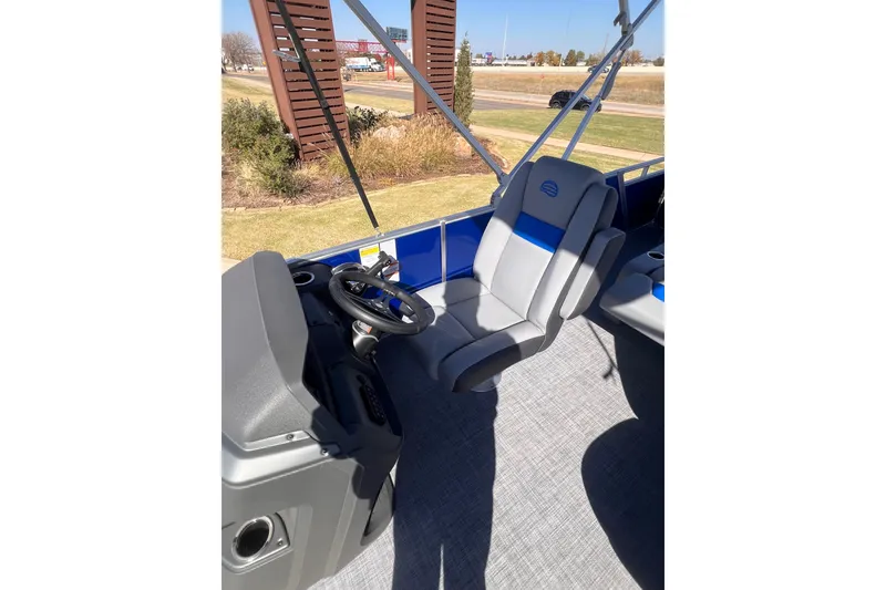 Slide: The Image of 2026 Sun Tracker Party Barge 22 RF DLX interior with steering wheel and seating. - 9