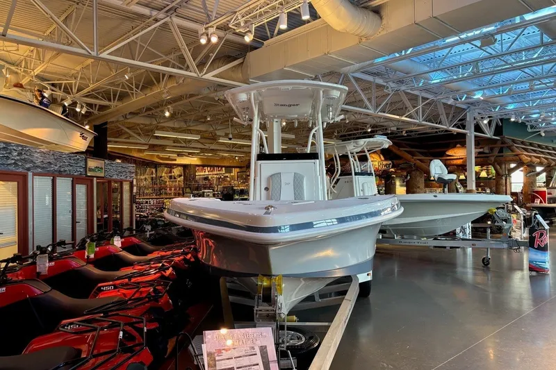 Slide: The Image of 2026 Ranger 2600 Bay boat displayed in a showroom with ATVs and other boats. - 10