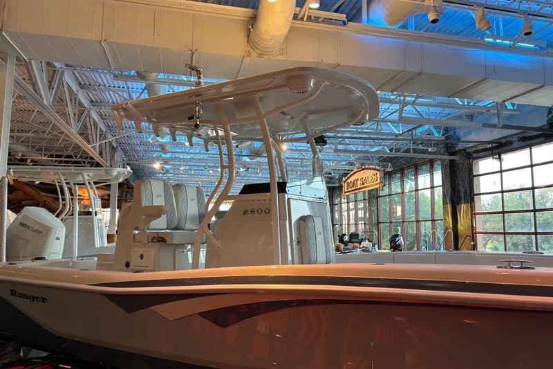 Slide: The Image of 2026 Ranger 2600 Bay boat displayed in a showroom with modern interior lighting. - 11