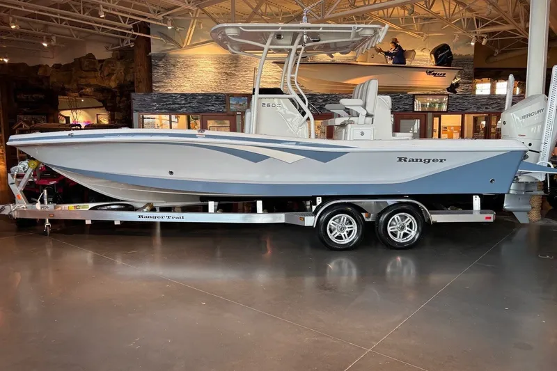 Slide: The Image of 2026 Ranger 2600 Bay boat on trailer in showroom, side view. - 9