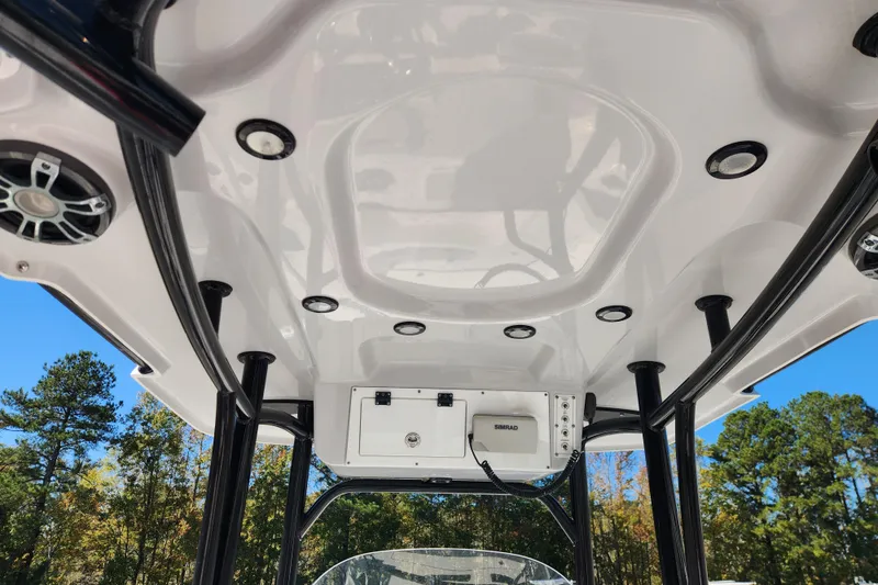 Slide: The Image of 2019 Sea Pro 248 Bay boat T-top with speakers and electronics, set against a clear sky. - 18