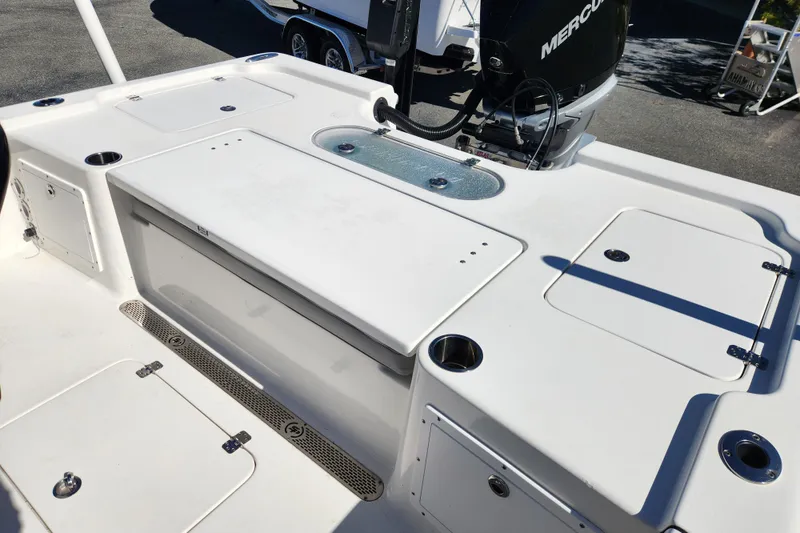 Slide: The Image of 2019 Sea Pro 248 Bay boat deck with storage compartments and Mercury engine. - 19